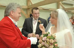 Toastmaster Richard Palmer handing bride and bridegroom a glass of champagne