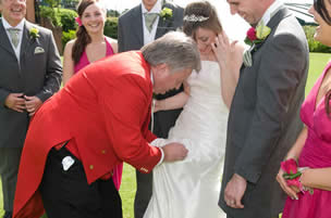 Toastmaster removing stain from bride's dress with dry cleaning kit at Stock Brook Manor Wedding